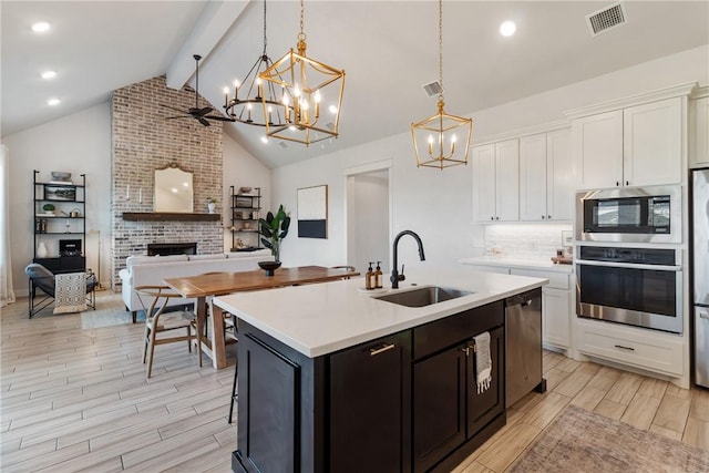 4209 Harding Ct, Bryan, TX 77802 - kitchen with appliances with stainless steel finishes, a sink, a chandelier, light wood-style flooring, and recessed lighting