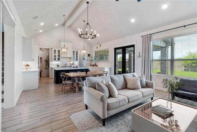 4209 Harding Ct, Bryan, TX 77802 - living area featuring a chandelier, beam ceiling, french doors, light wood-style floors, and high vaulted ceiling