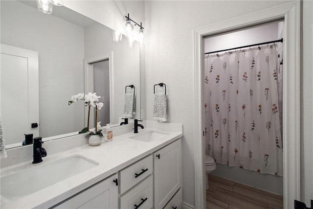 4209 Harding Ct, Bryan, TX 77802 - bathroom with toilet, double vanity, shower / tub combo, and wood finished floors