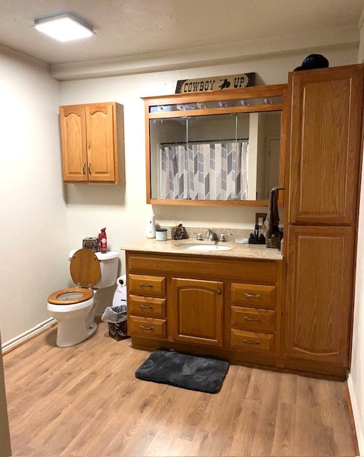 full bath featuring crown molding, vanity, toilet, curtained shower, and wood finished floors