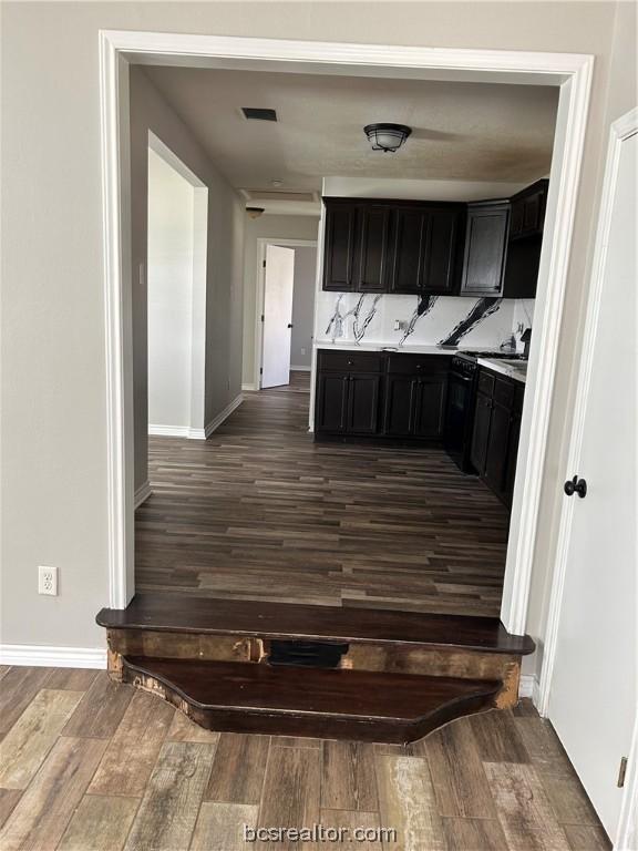 kitchen with backsplash and dark wood-type flooring