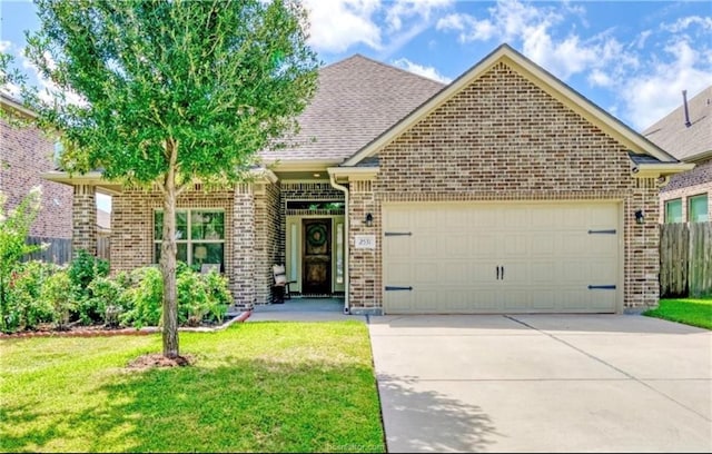 view of front of house featuring an attached garage, brick siding, fence, concrete driveway, and a front lawn