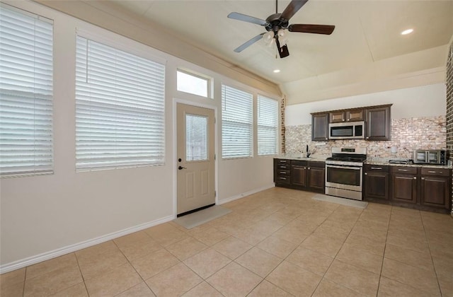 kitchen with light tile patterned flooring, light countertops, appliances with stainless steel finishes, dark brown cabinets, and decorative backsplash