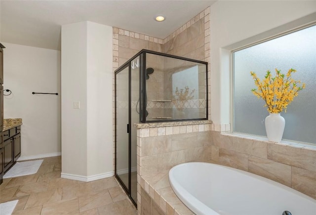 full bath featuring a stall shower, a garden tub, vanity, and baseboards