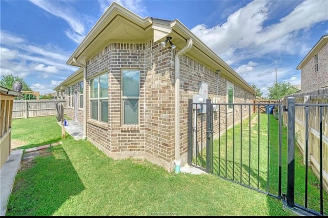 view of home's exterior featuring brick siding, a yard, and a fenced backyard