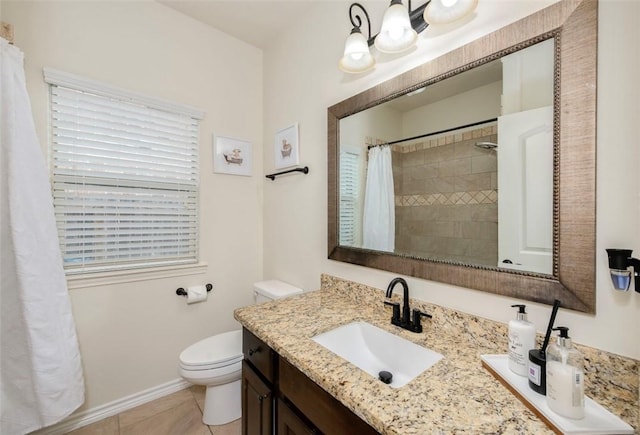 bathroom with tile patterned flooring, toilet, vanity, baseboards, and tiled shower