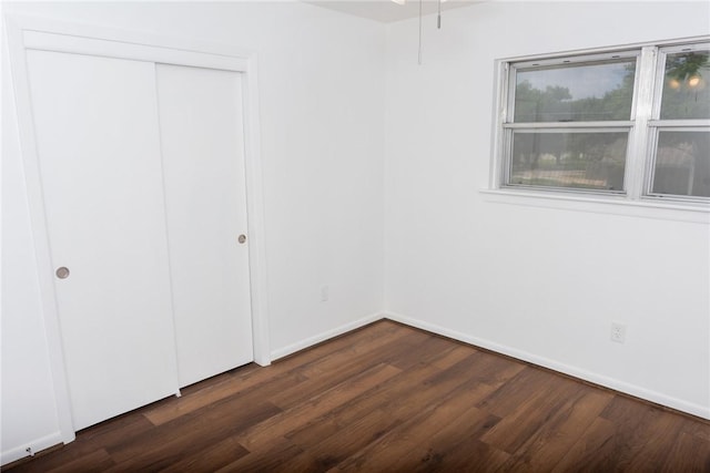 2323 Carter Creek Pkwy, Bryan, TX 77802 - unfurnished bedroom with dark wood-type flooring, a closet, and baseboards