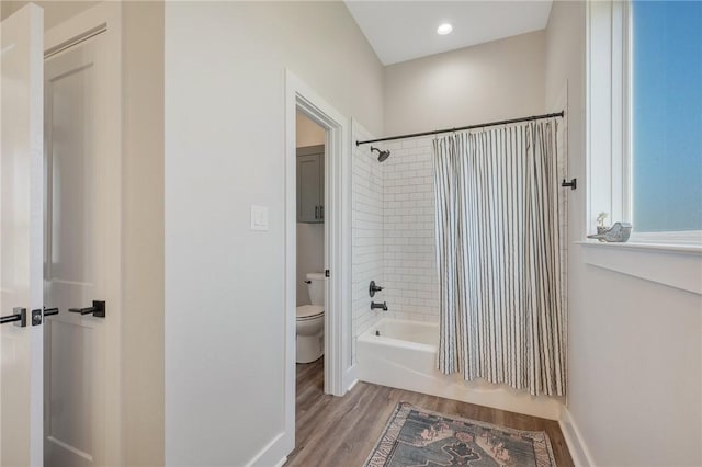 bathroom with wood-type flooring, toilet, and shower / bath combo with shower curtain