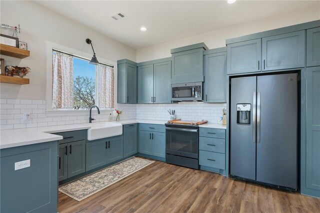 kitchen with sink, decorative backsplash, dark hardwood / wood-style flooring, and stainless steel appliances