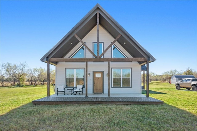 rear view of property featuring a yard and a porch