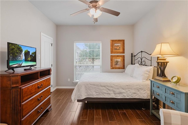 bedroom featuring dark wood-style flooring, a ceiling fan, and baseboards