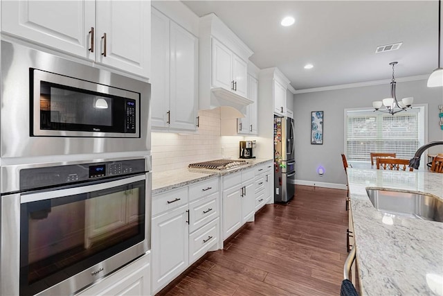 kitchen with a sink, visible vents, white cabinets, appliances with stainless steel finishes, and tasteful backsplash