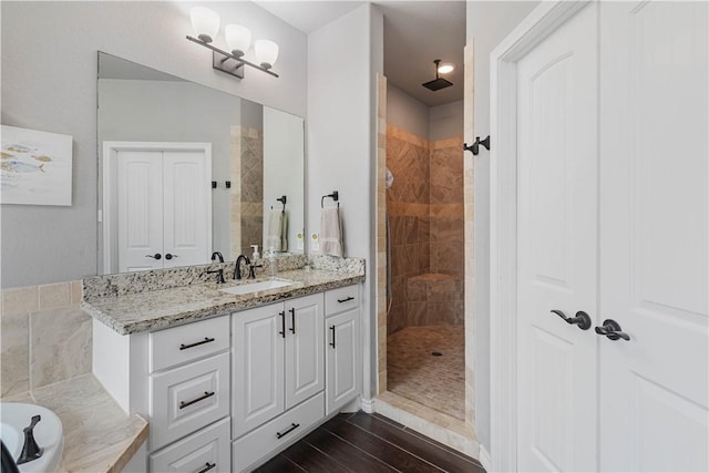 full bathroom featuring a bathtub, a tile shower, vanity, and wood finished floors