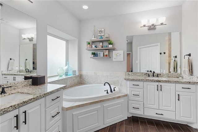 full bath with a garden tub, a sink, and wood finished floors