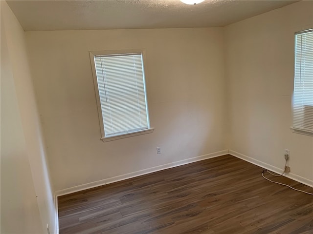 unfurnished room with dark hardwood / wood-style flooring