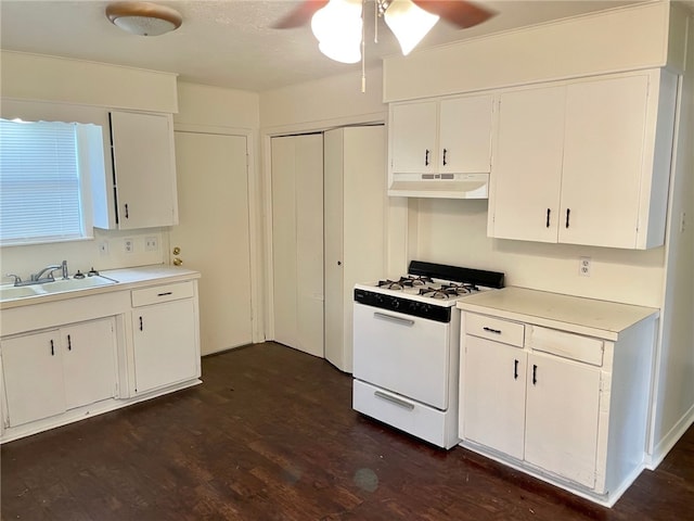 kitchen featuring dark hardwood / wood-style flooring, white cabinetry, gas range gas stove, and sink