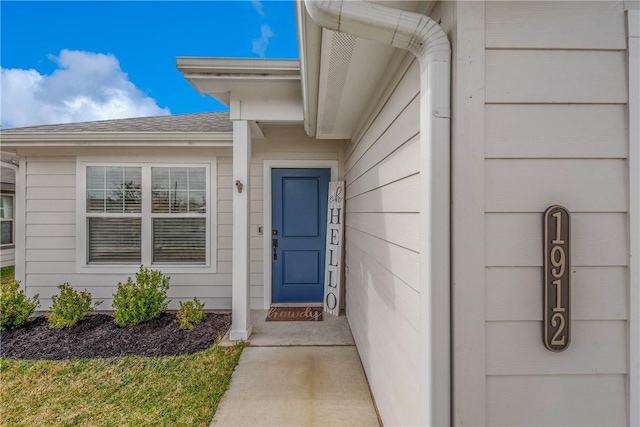 entrance to property with roof with shingles