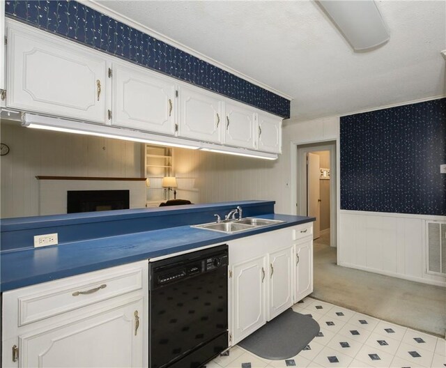 kitchen with dishwasher, dark countertops, a sink, and light colored carpet