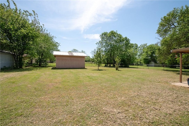 view of yard featuring fence and an outbuilding
