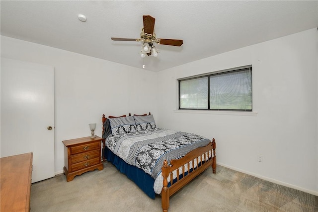 bedroom featuring baseboards, light colored carpet, and ceiling fan