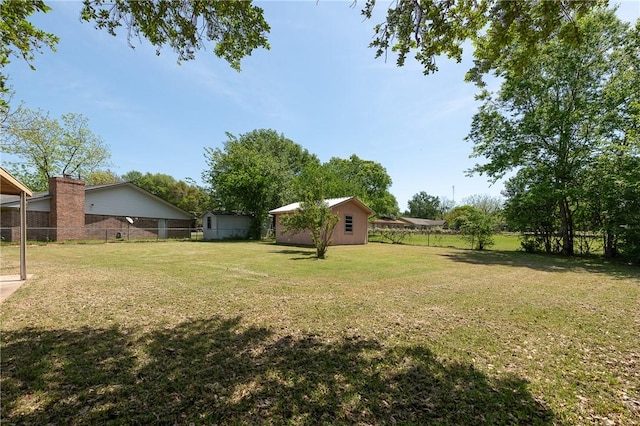 view of yard with an outbuilding and fence