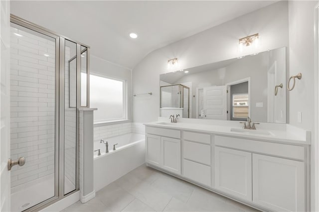 full bath featuring a sink, a garden tub, a stall shower, and double vanity