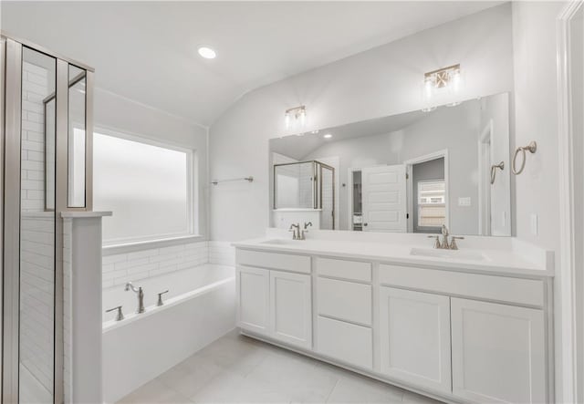 full bath with a sink, a shower stall, double vanity, a bath, and vaulted ceiling