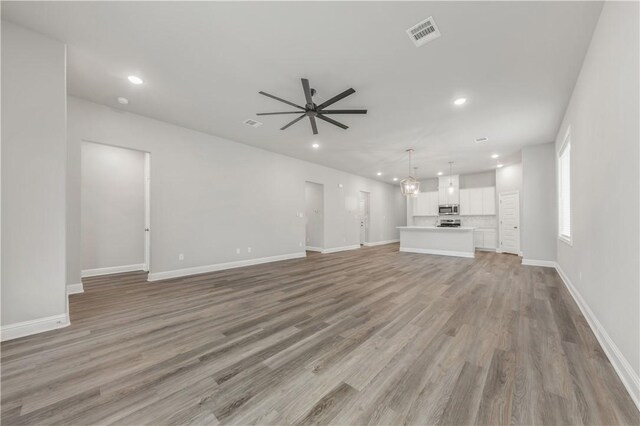 unfurnished living room with visible vents, baseboards, ceiling fan, light wood-type flooring, and recessed lighting