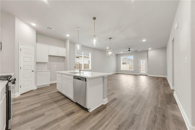 kitchen with visible vents, light wood-style flooring, a sink, stainless steel appliances, and white cabinets