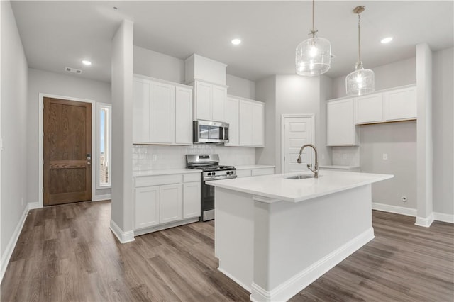 kitchen with visible vents, appliances with stainless steel finishes, wood finished floors, and a sink