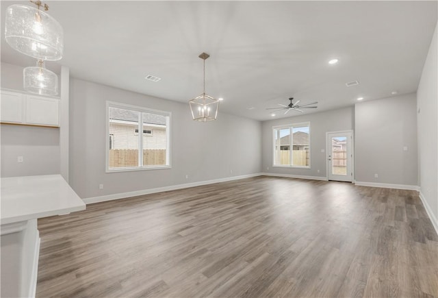 unfurnished living room with baseboards and light wood-type flooring