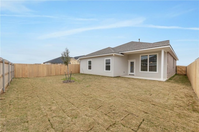 back of house featuring a patio area, a fenced backyard, and a lawn