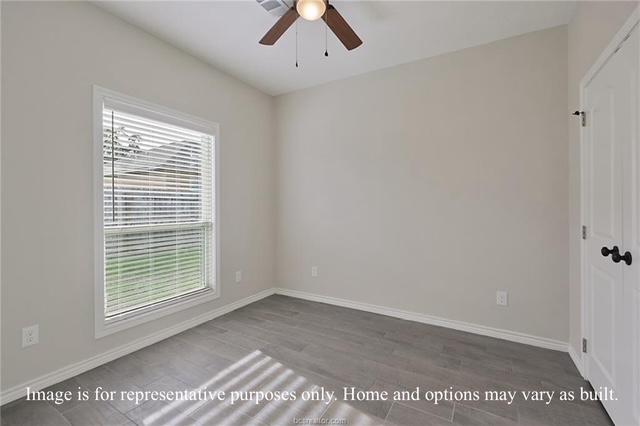 empty room with a ceiling fan, baseboards, and wood finished floors