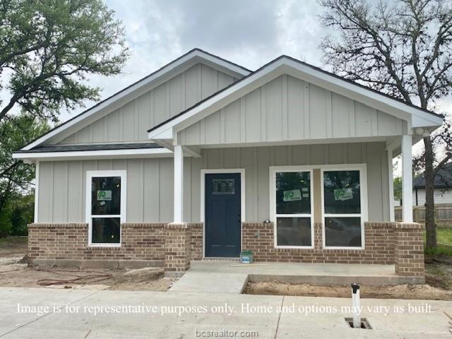 view of front of home featuring brick siding and board and batten siding