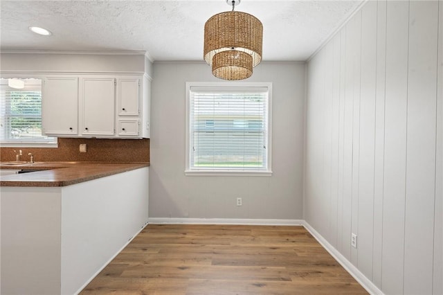 2909 River Oaks Cir, Bryan, TX 77802 - unfurnished dining area featuring wood finished floors, crown molding, a chandelier, baseboards, and a textured ceiling