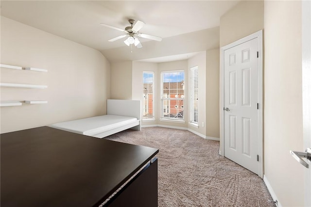 unfurnished bedroom with ceiling fan, lofted ceiling, and light carpet