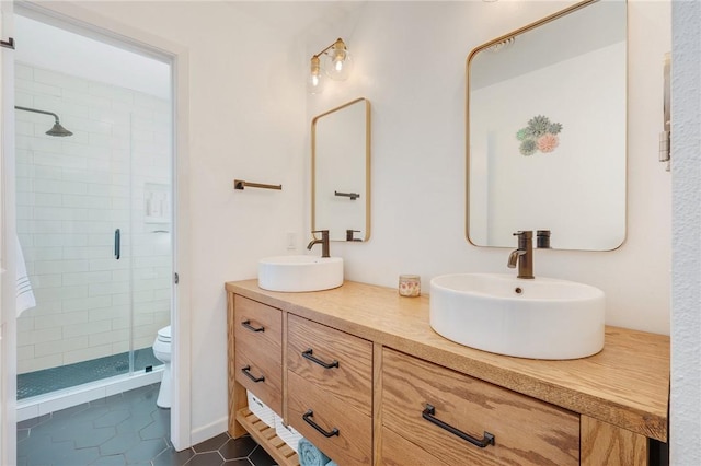 bathroom with toilet, a shower with shower door, tile patterned floors, and vanity