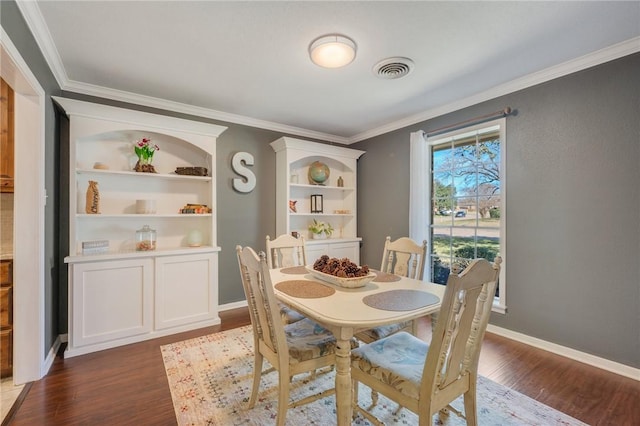 dining room featuring dark wood-type flooring and crown molding