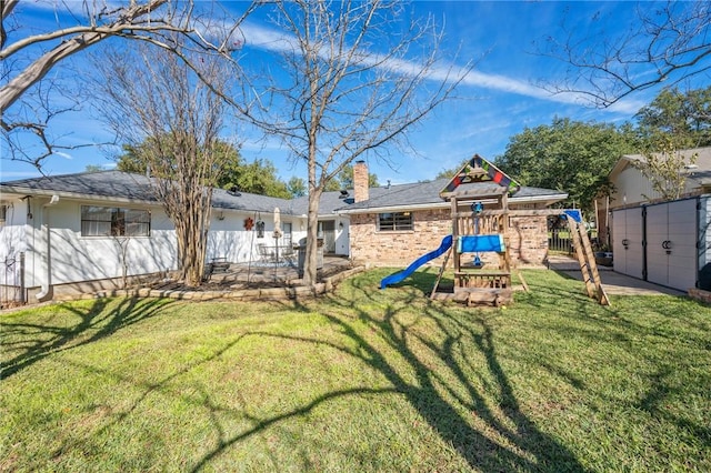 back of house with a yard and a playground