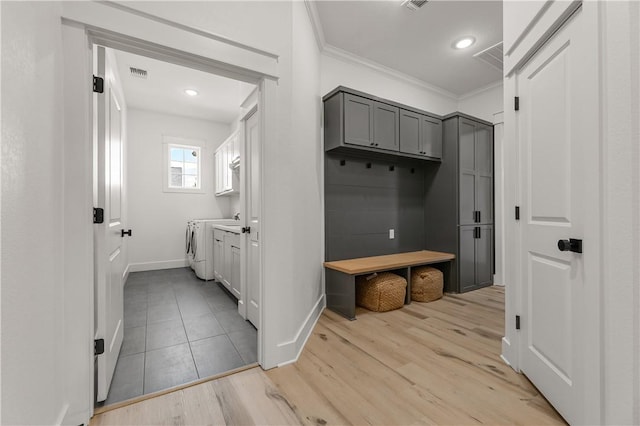 mudroom with ornamental molding, separate washer and dryer, and light hardwood / wood-style floors