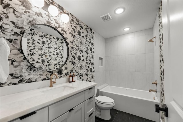 full bathroom with vanity, tile patterned flooring, tiled shower / bath combo, and toilet