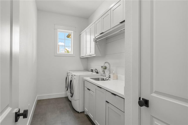 washroom featuring cabinets, washing machine and dryer, and sink