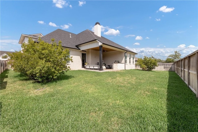 rear view of property featuring a patio and a lawn