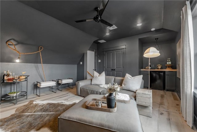 home theater with lofted ceiling, light hardwood / wood-style flooring, and ceiling fan