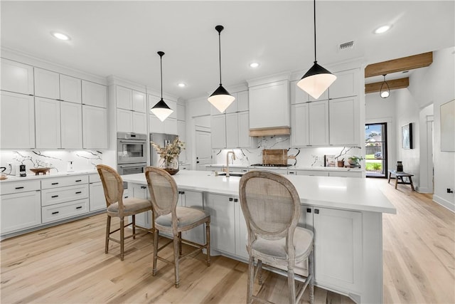 kitchen featuring decorative light fixtures, a spacious island, and premium range hood