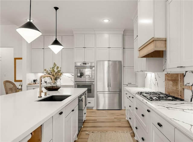 kitchen featuring sink, decorative light fixtures, stainless steel appliances, and white cabinets