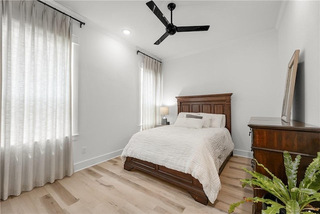 bedroom with crown molding, light hardwood / wood-style floors, and multiple windows