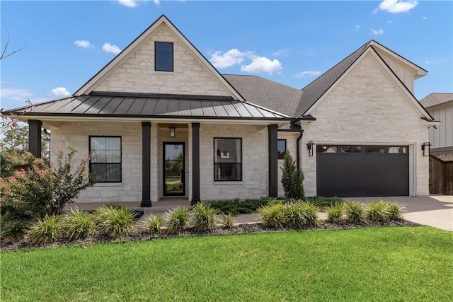 view of front of property featuring a garage, a front yard, and a porch