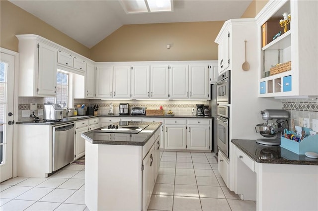 4719 Hunington Dr, Bryan, TX 77802 - kitchen featuring stainless steel appliances, decorative backsplash, light tile patterned floors, white cabinetry, and a kitchen island