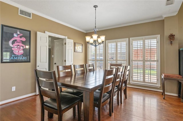 4719 Hunington Dr, Bryan, TX 77802 - dining area with a chandelier, wood finished floors, and crown molding